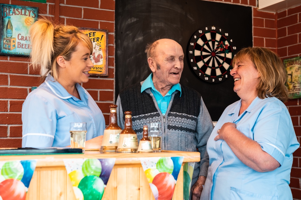 staff and resident socialising in nursing home pub